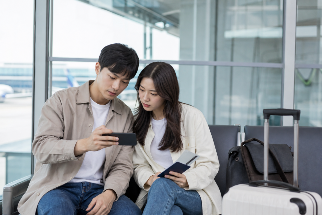 공항 라운지에서 신혼부부가 여행 이동 시간을 확인하는 모습